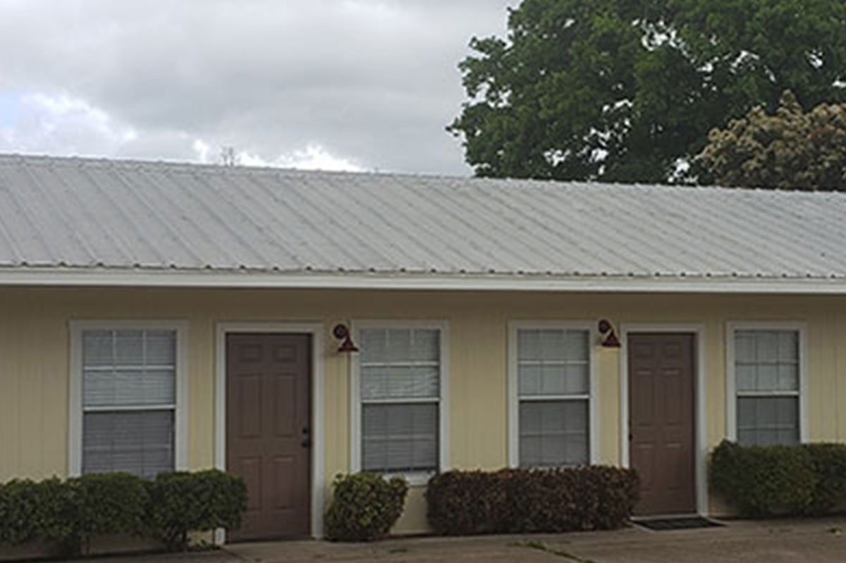 Exterior of the duplexes adorned with yellow walls and brown doors with green hedges neatly trimmed