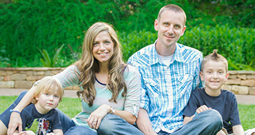 Owners, Allen and Sarah Sheehan, pictured with their young boys sitting on the grass with a lush background