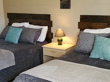 Image of made beds inside motel room with new, wooden headboards