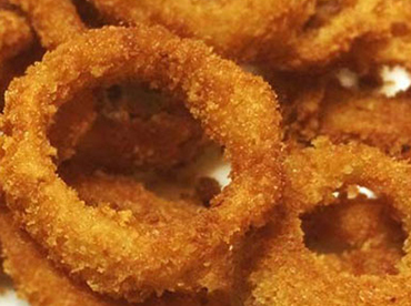 Fried, golden-brown, onion rings on a white plate